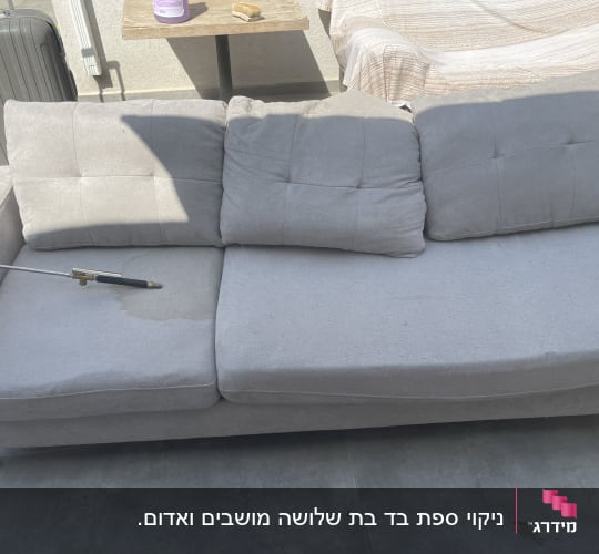 ספה אפורה עם מכשיר ניקוי בלחץ מים